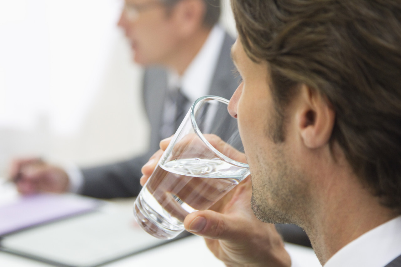 Homme buvant un verre d'eau
